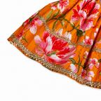 close up shot of colourful floral dress with gold trim