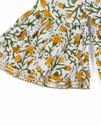 Floral patterned fabric with yellow flowers and green leaves on a white background