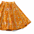 Orange floral skirt with decorative trim on a white background
