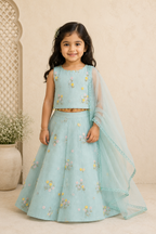 Young girl in a light blue embroidered traditional outfit with a beige background