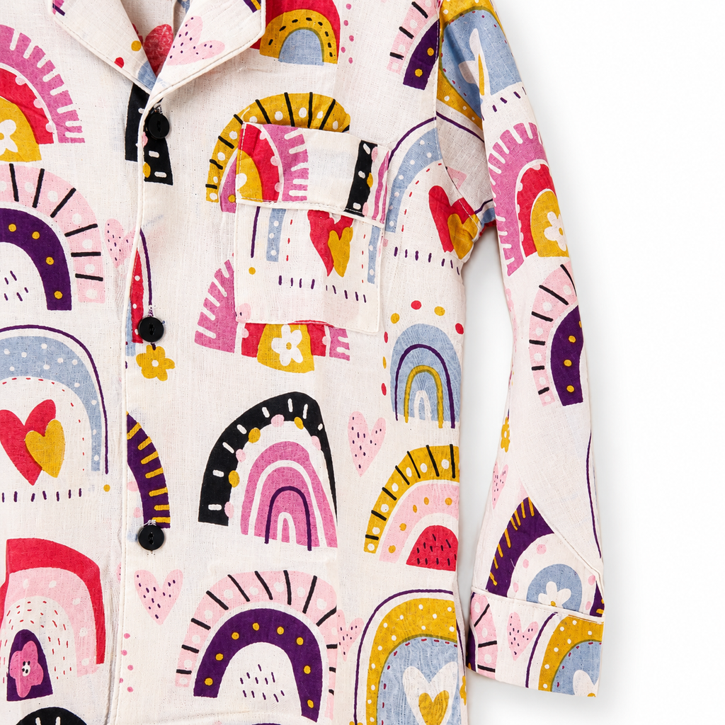 Colorful patterned fabric with rainbows and abstract shapes on a white background