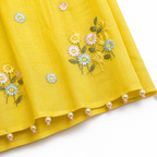 Yellow fabric with floral embroidery and pearl embellishments on a white background
