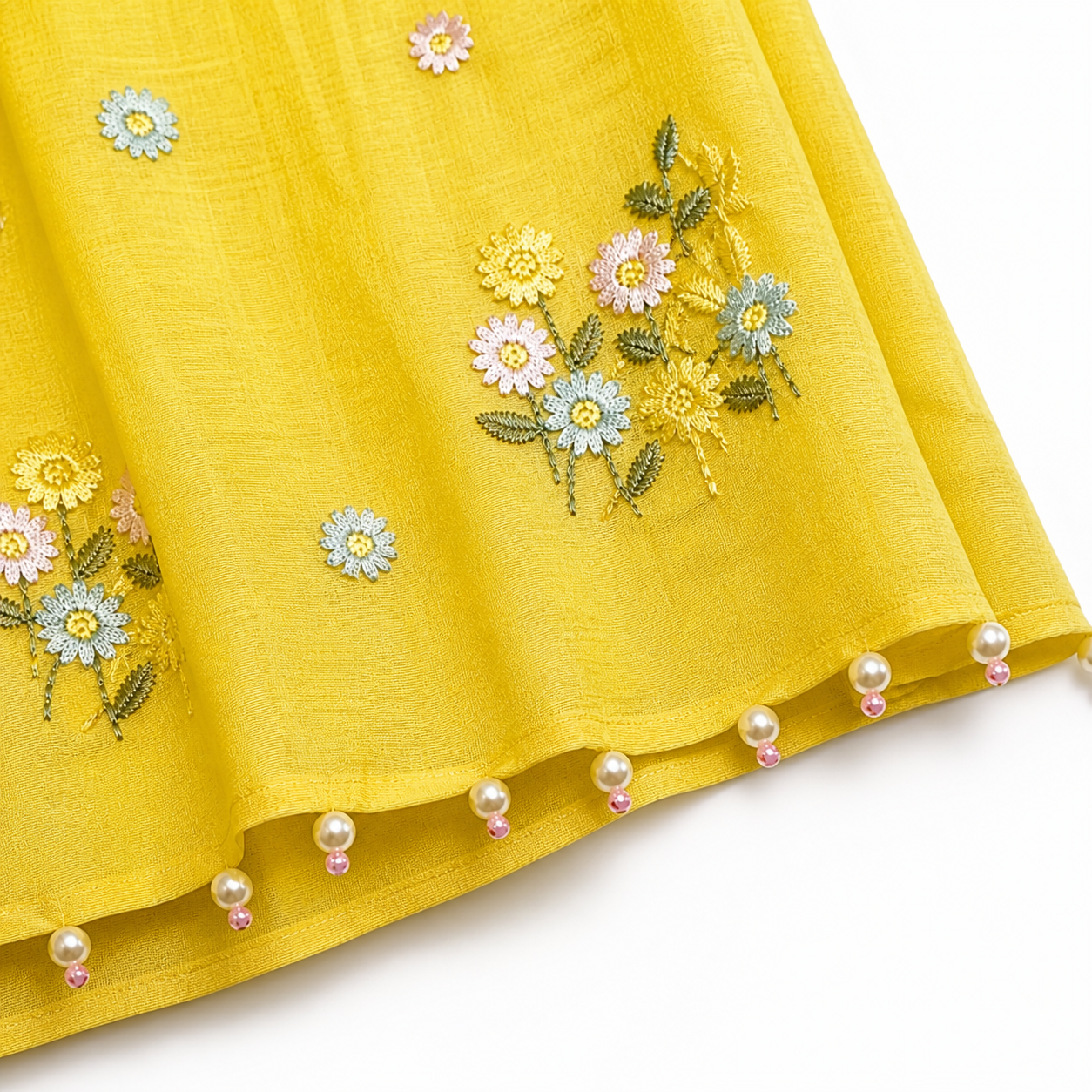 Yellow fabric with floral embroidery and pearl embellishments on a white background