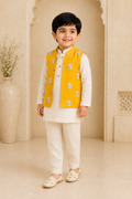 Child wearing a traditional outfit with a yellow vest in an elegant interior setting