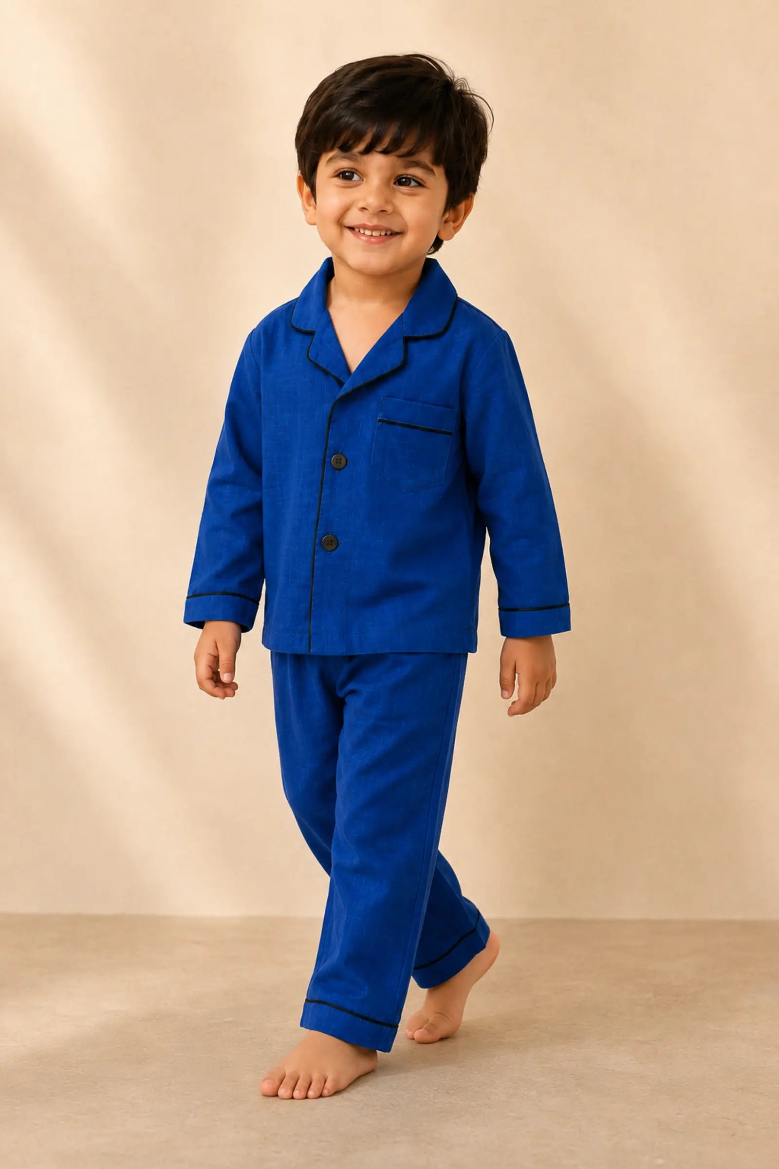 Boy wearing classic dark blue piped night suit in movement