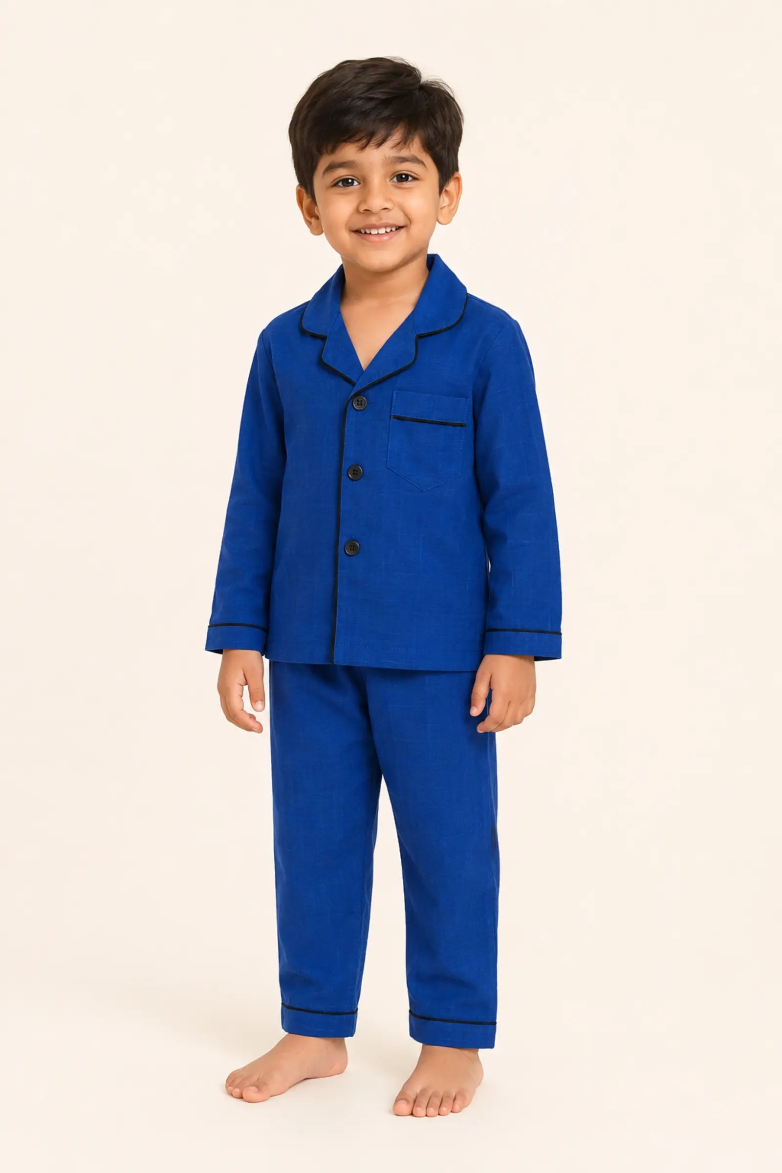 Boy wearing classic dark blue piped kids night suit, standing view