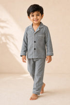 Boy wearing grey white-piped kids night suit in movement