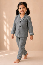 Girl wearing grey white-piped kids night suit in movement