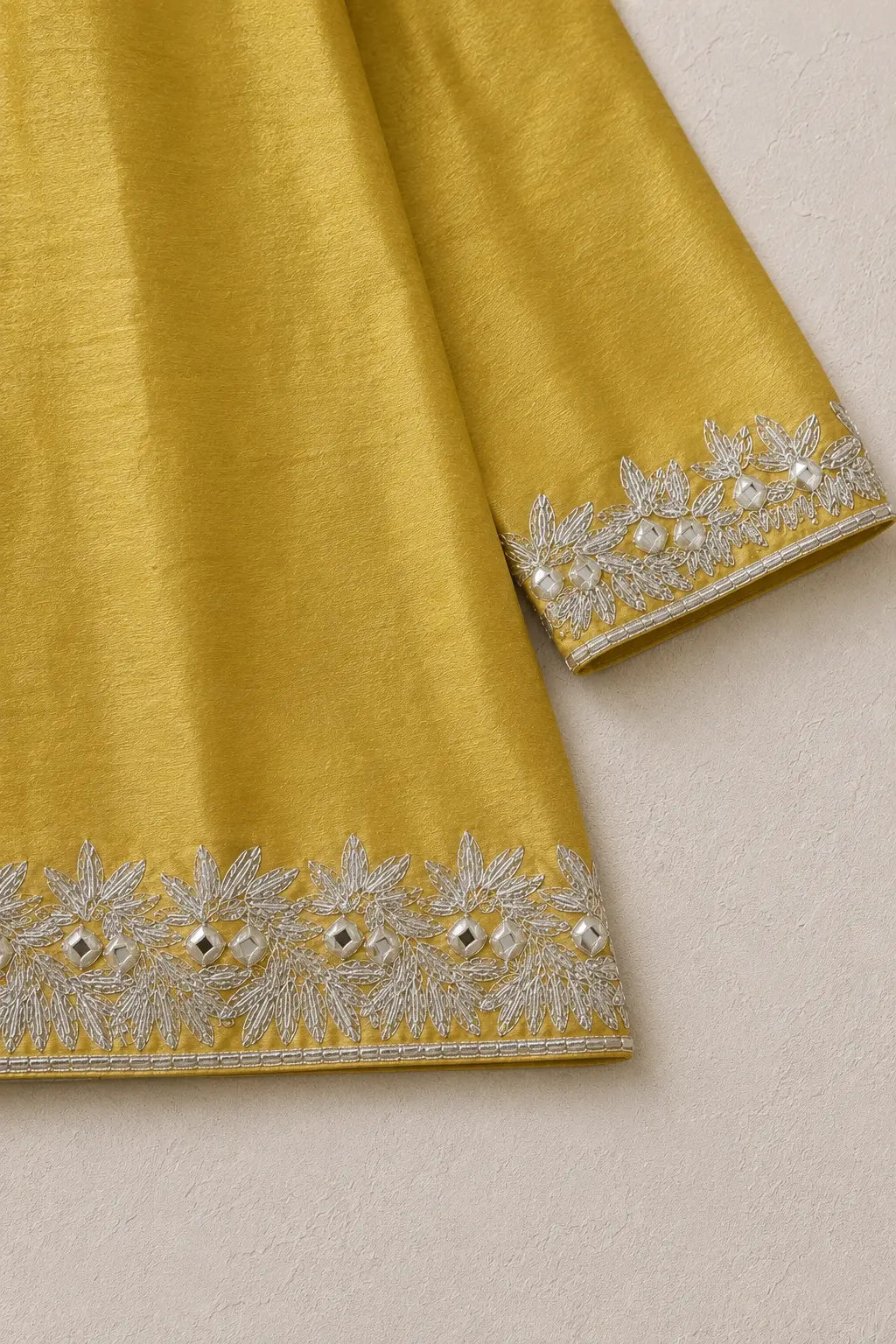 Close-up of gota work on the three-quarter sleeve cuff and kurta hem
