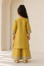 Back view of girl in mustard kurta and flared pants