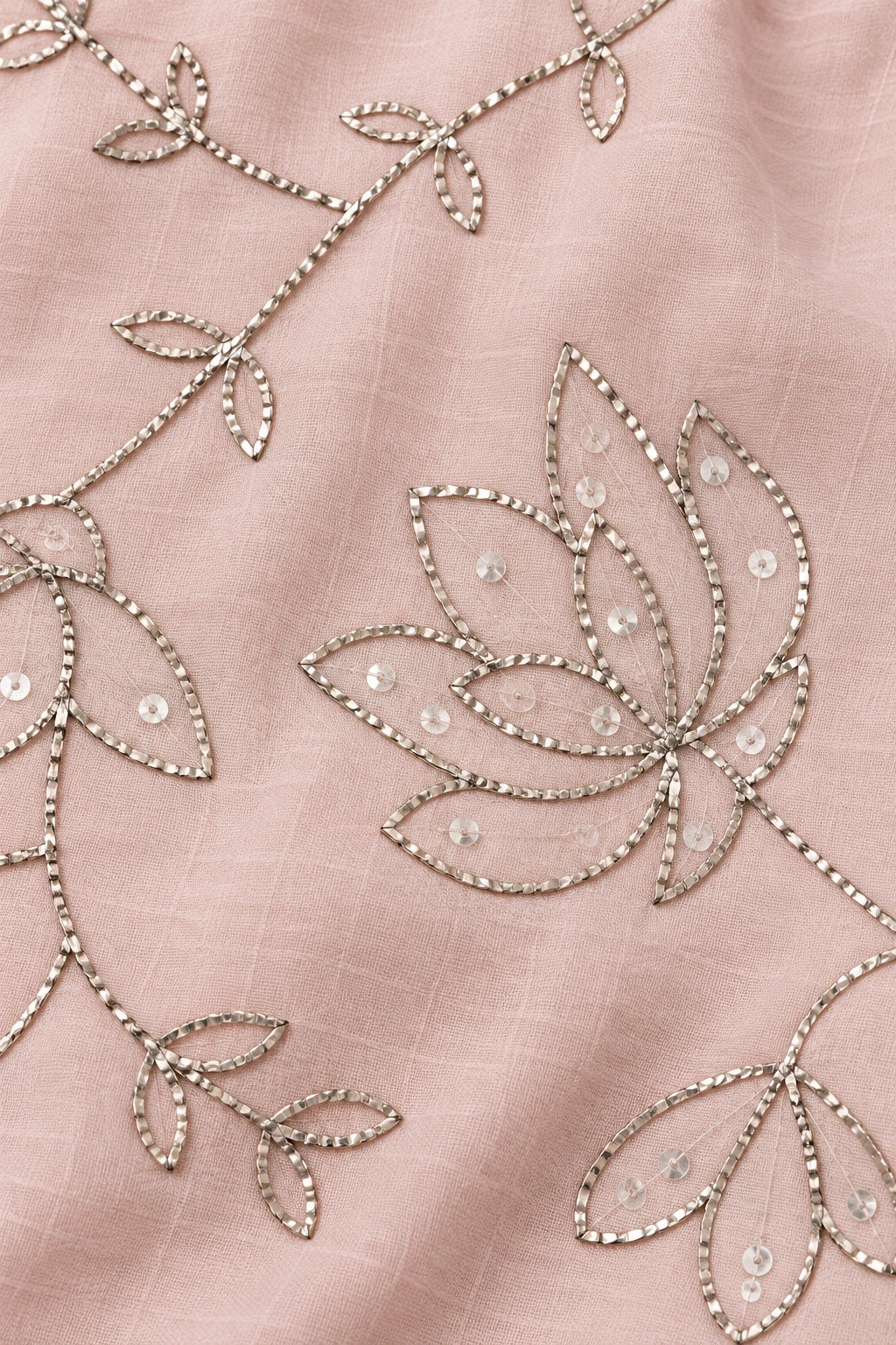 Close-up of flattened metallic floral pita work and small sequins on nude pink mulmul fabric