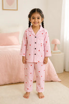 Girl wearing pink striped heart print night suit, front view