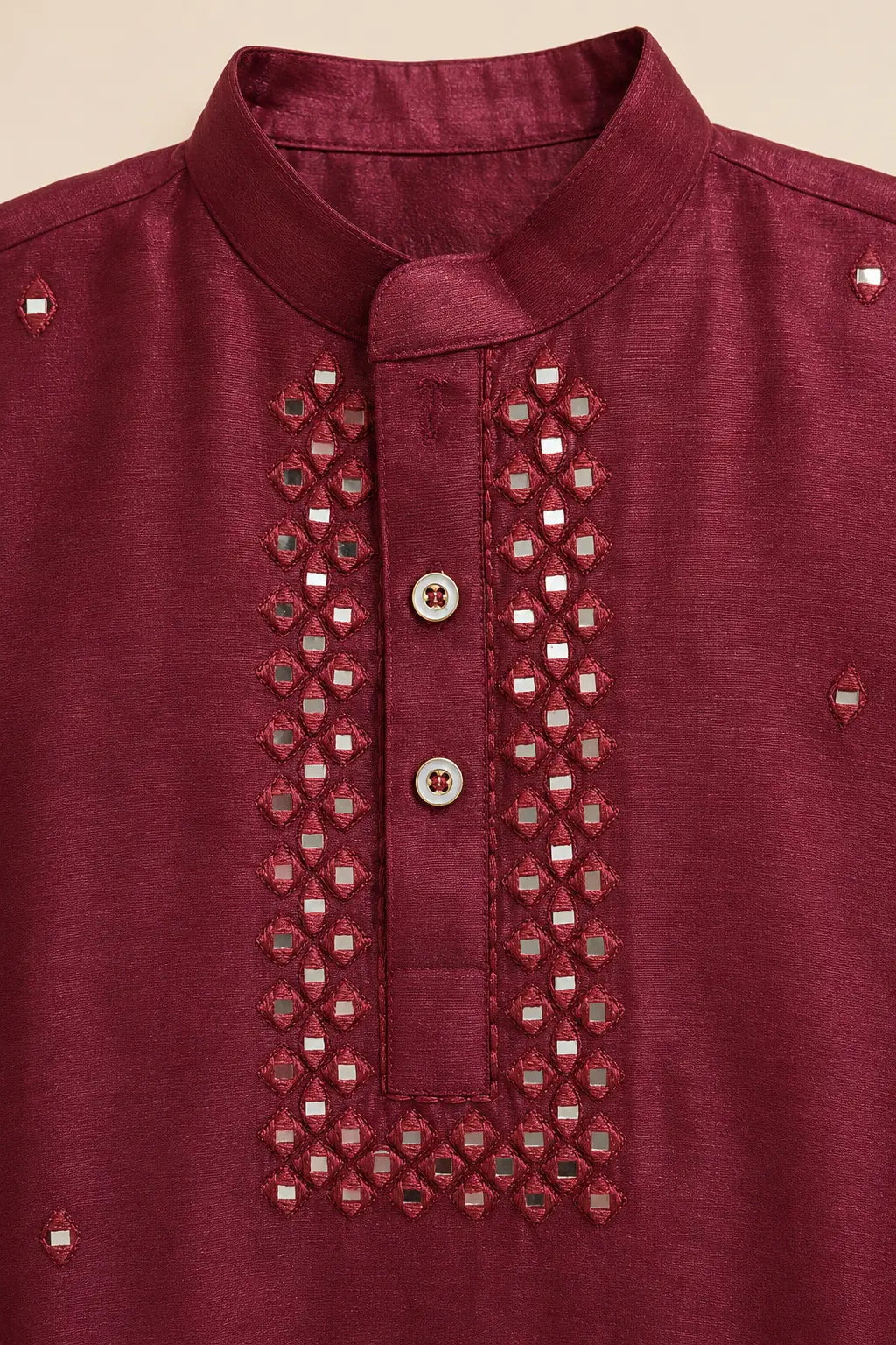 Close-up of mirror-look detailing on the ruby red kurta placket