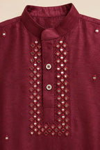 Close-up of mirror-look detailing on the ruby red kurta placket