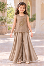 Girl wearing a taupe gold tissue-organza handwork top and satin palazzo trousers, front view